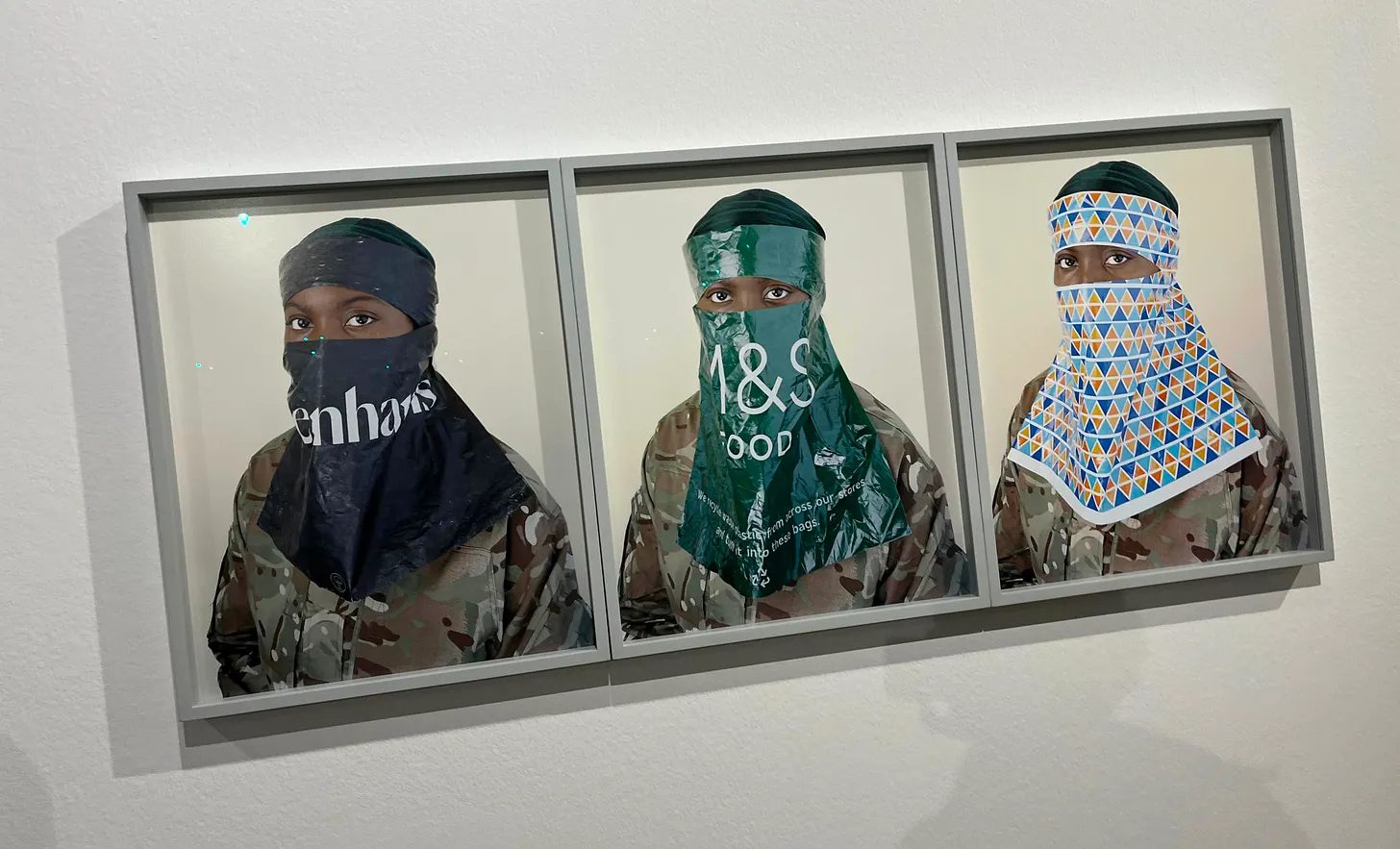 Instalação na Sociedade Nacional de Belas Artes, com obras nas paredes brancas.