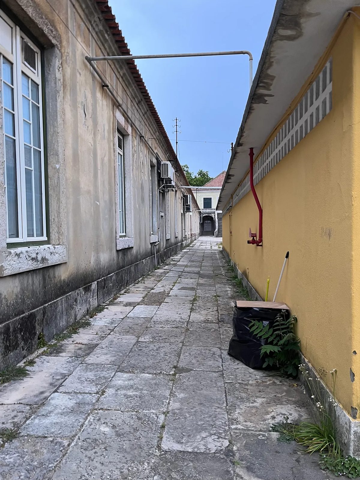 Viela estreita ao lado de um edifício amarelo.