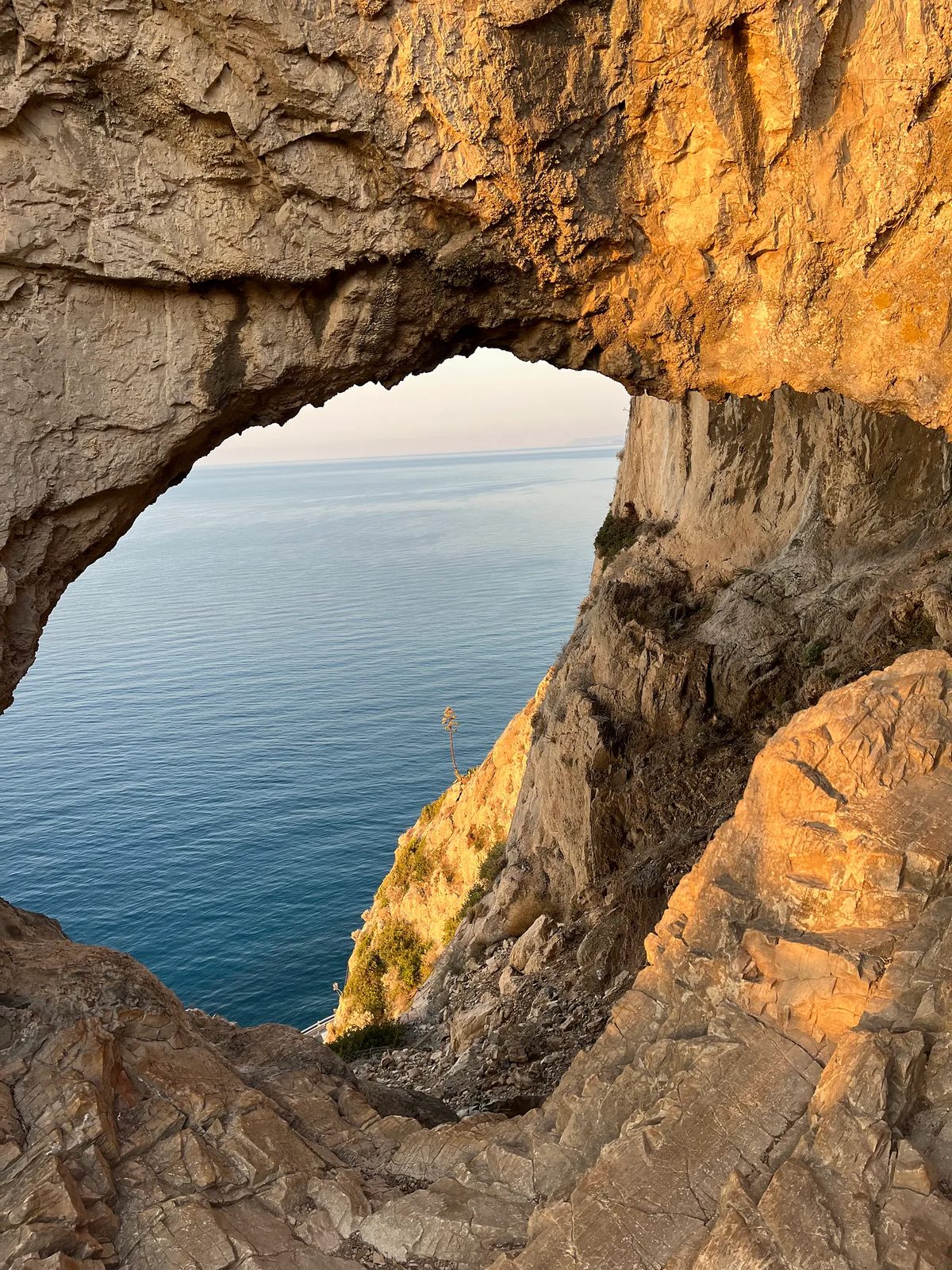 Arco natural de rocha sobre o mar.
